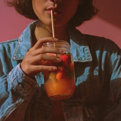 This shows a woman drinking a fruit juice.