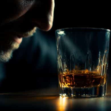This shows a drink and a man's face with a black background.