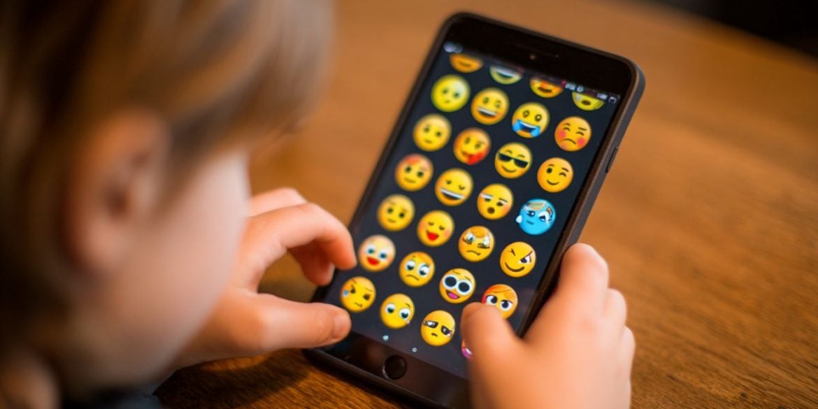 This shows a kid using an app full of emojis.