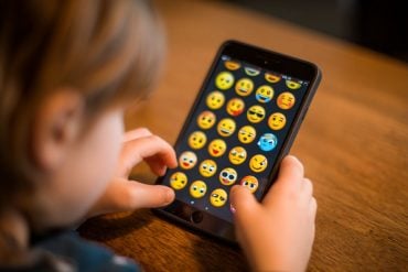 This shows a kid using an app full of emojis.