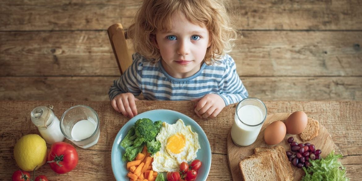 This shows a child sitting with a plate of food.