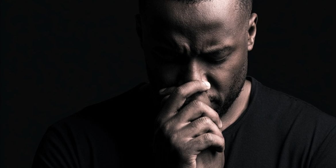 This shows a depressed man with his hands to his nose.