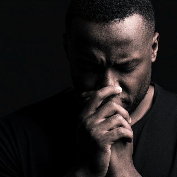 This shows a depressed man with his hands to his nose.