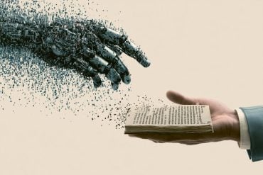 This shows a hand holding a book and a robotic hand.